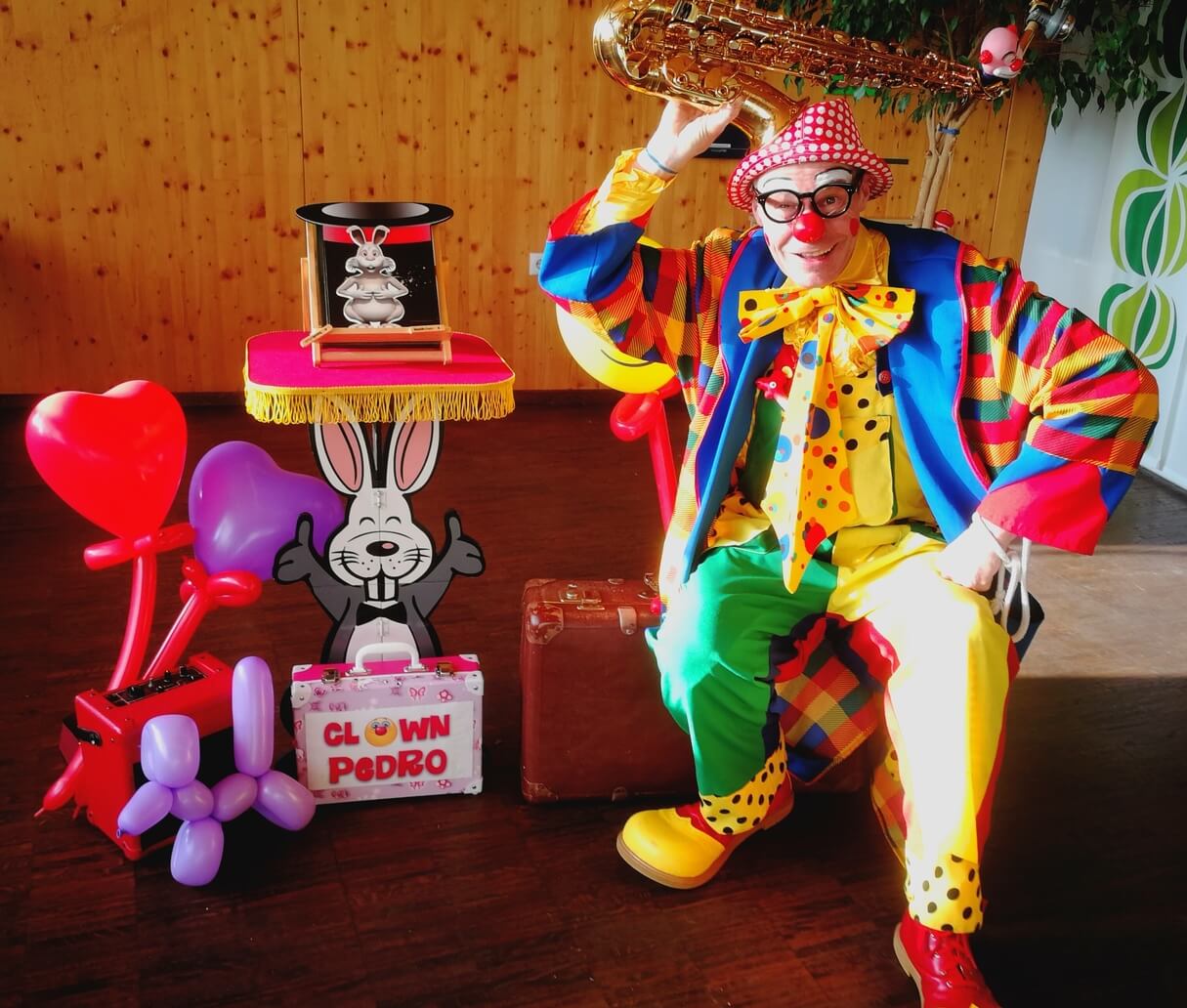 Clown Pedro bei Kindergeburtstagsfeier mit Hase und Luftballons.