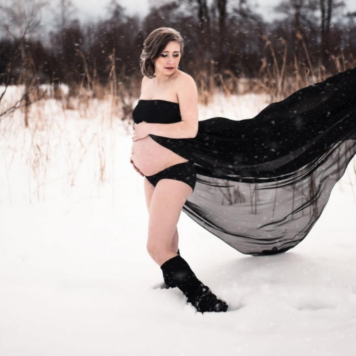 Volgergrafie fotografiert Schwangere im Schnee.