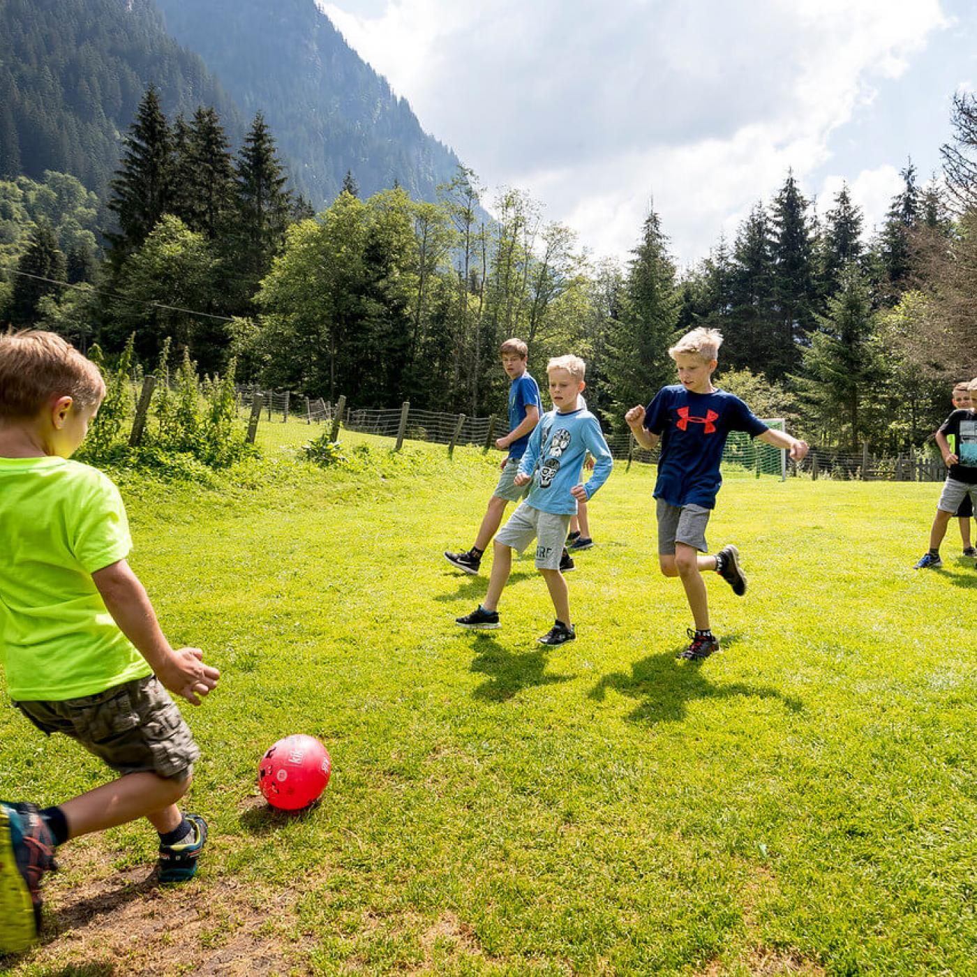 Kinder spielen auf der Waldhäuslalm Fussball.