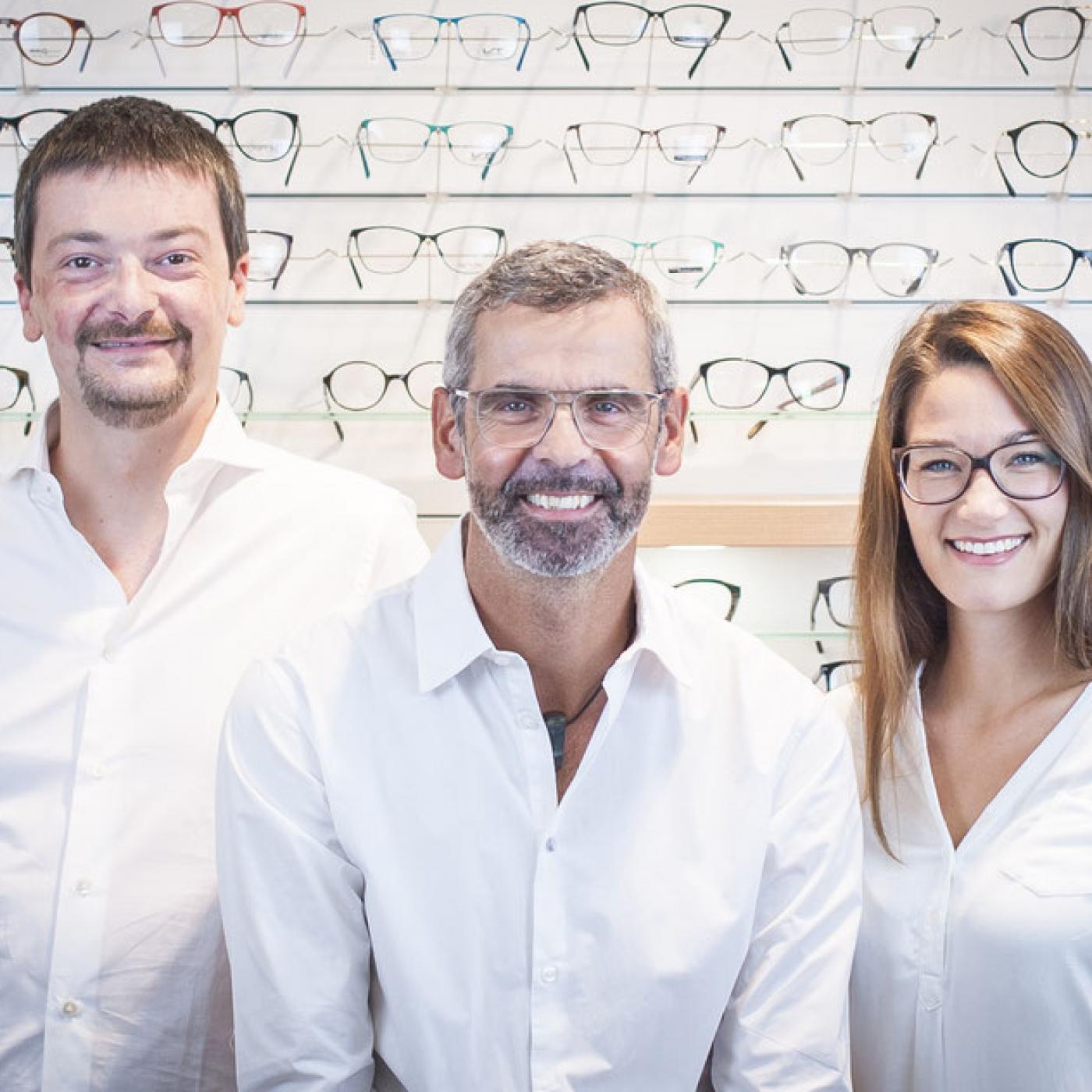 Team von Optik Stöckl  vor Brillenwand