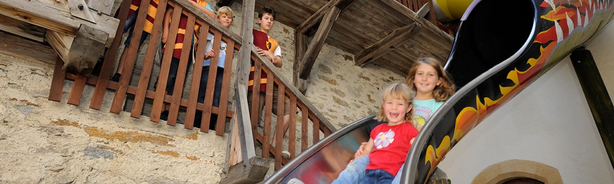 Kinder rutschen auf der Burg Mauterndorf. 